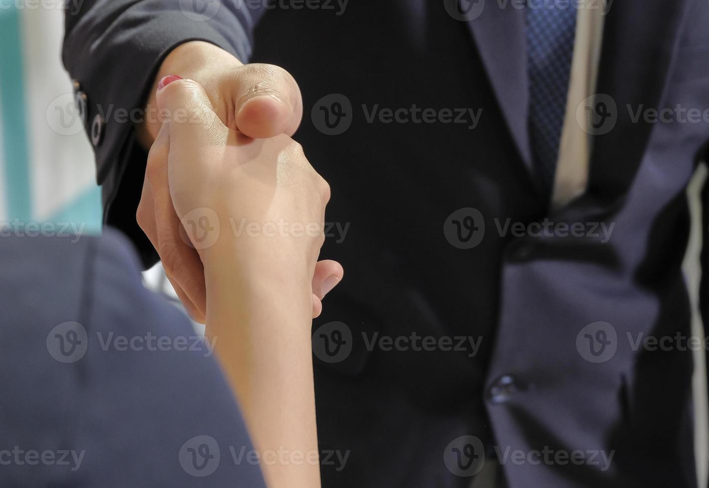 Close up two diversity business people shaking hands when reach an agreements. Business people hand shake after they have finished interview. photo