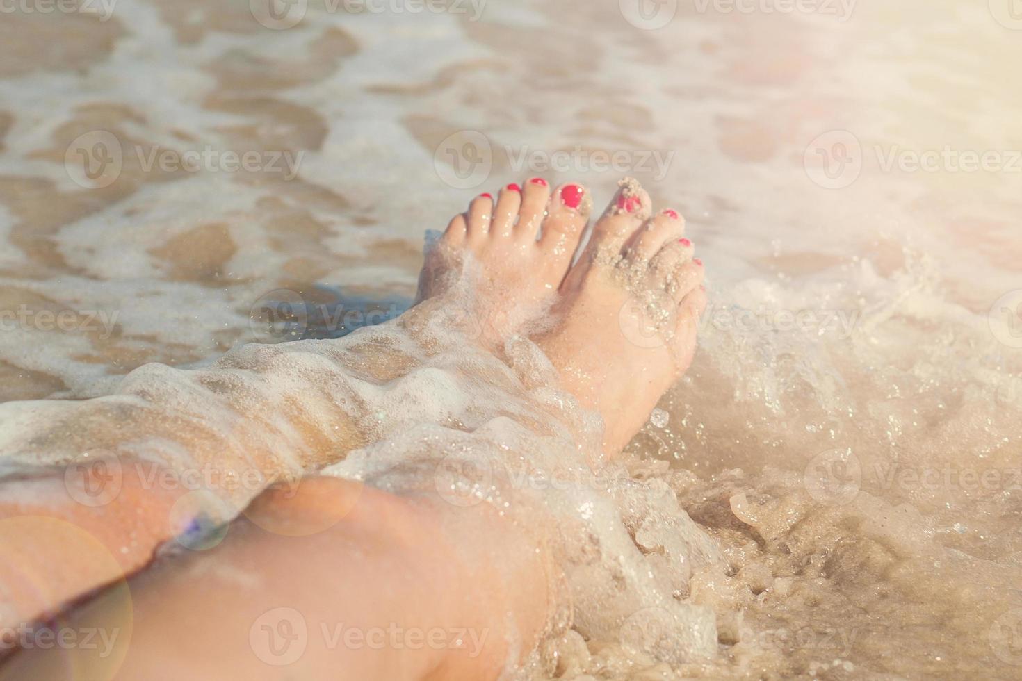 piernas de niña en el mar foto