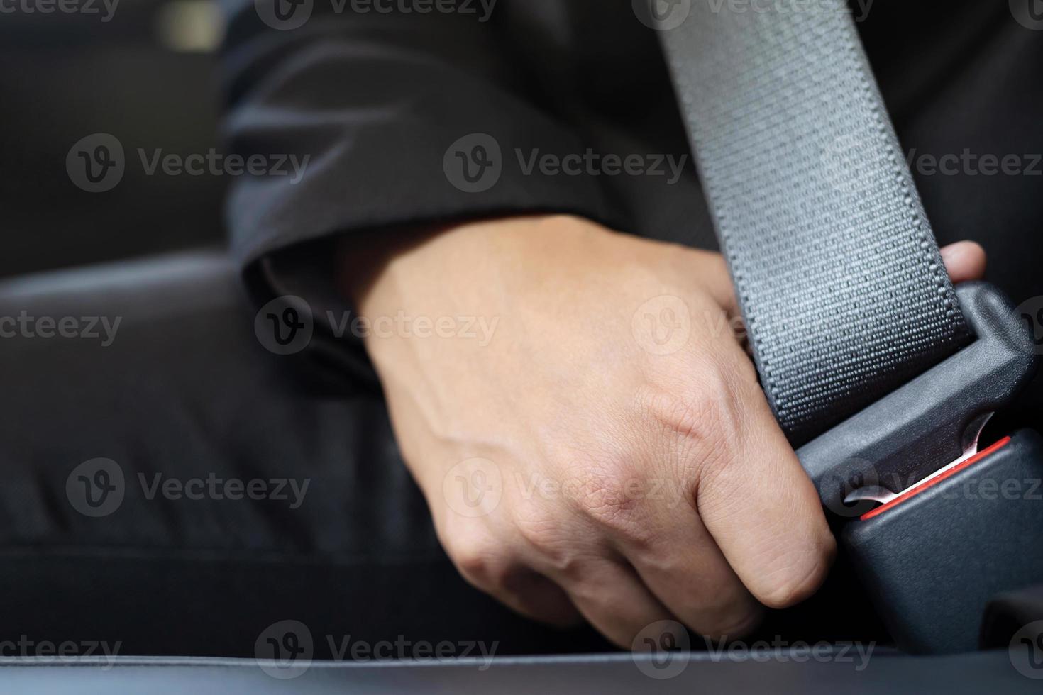 Close Up of people business man hand fastening seat safety belt in car photo