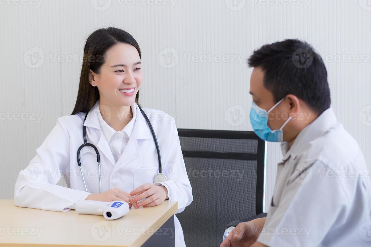 una doctora asiática habla y anima a un paciente hombre foto