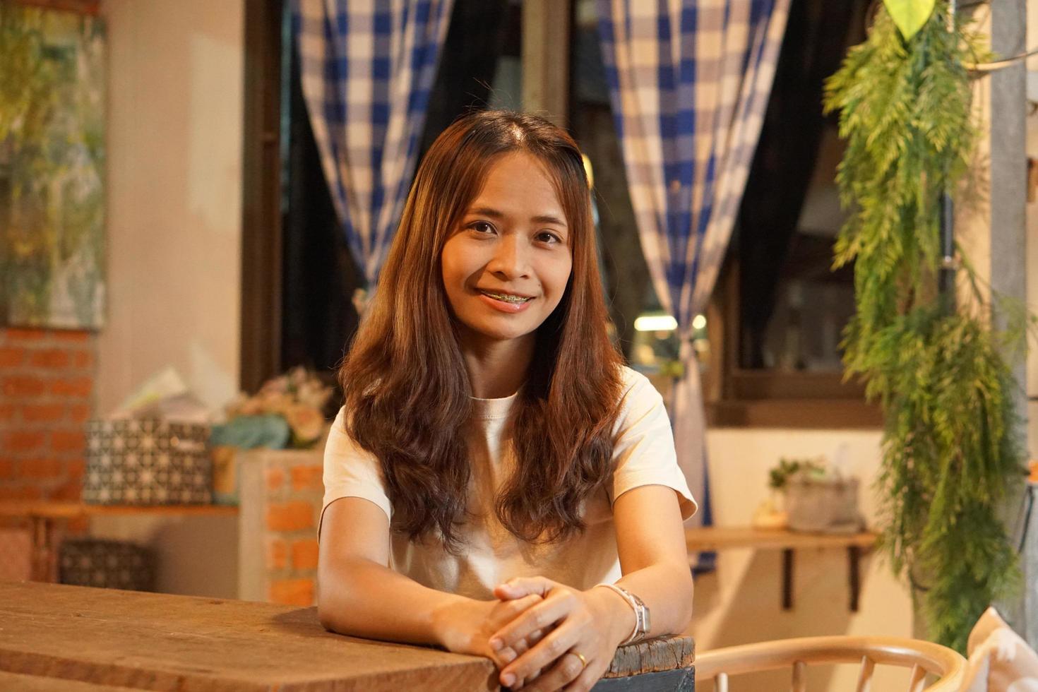 mujer asiática sonriendo alegremente en un café foto