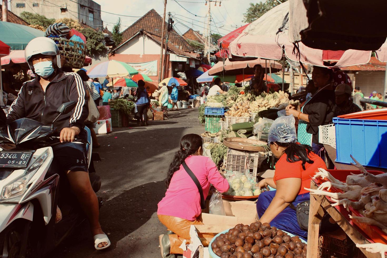 foto de varias personas realizando actividades de compra y venta en la zona del mercado kumbasari.
