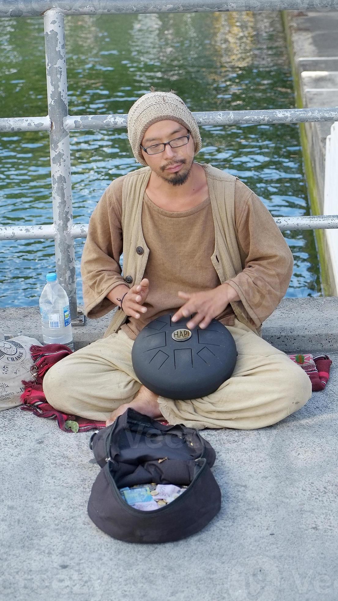 Male busker playing a Steel Tongue Percussion Drum Handpan Instrument ...