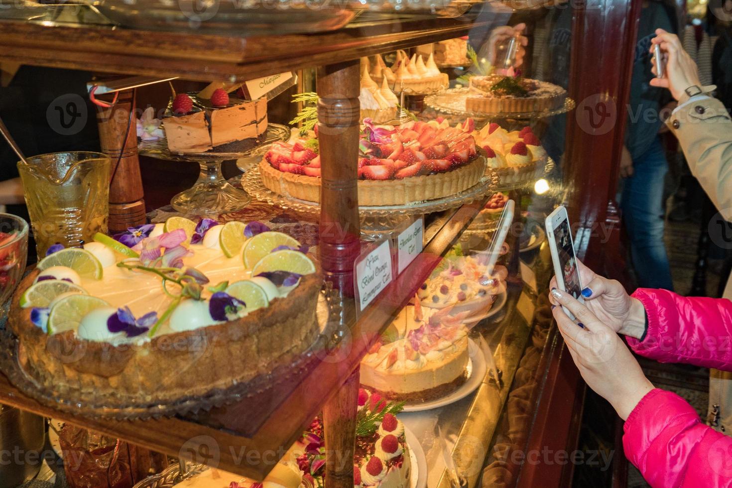 People photographing sweets stand in a shop photo