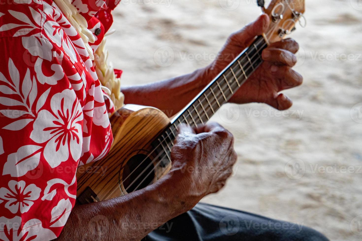 manos de anciano jugando hukulele en la polinesia francesa foto