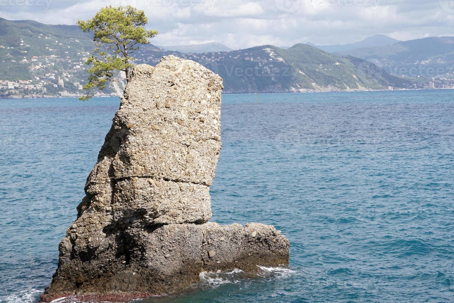 boot shape rock in the sea photo