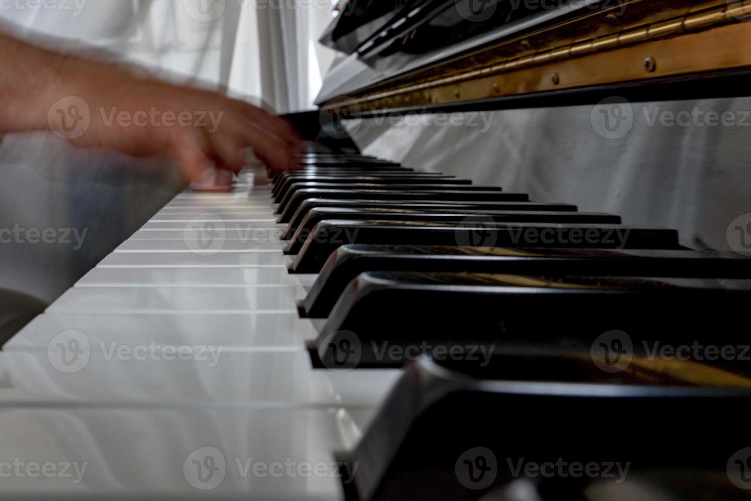 Hands playing piano while moving photo