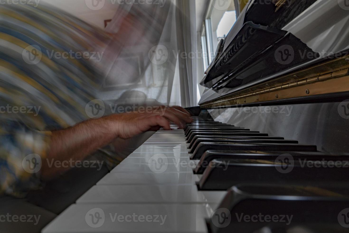 Hands playing piano while moving photo