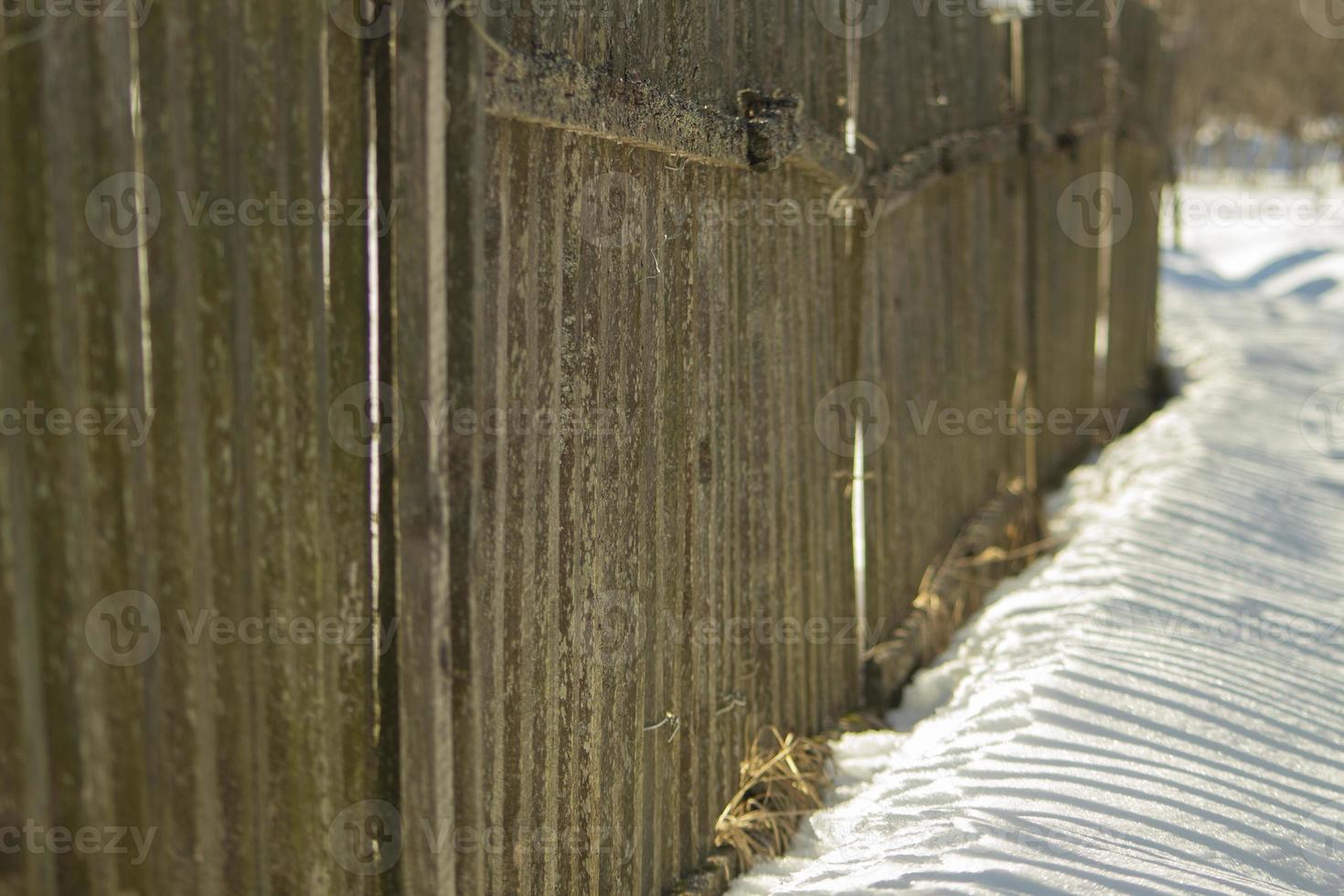 Fence made of wood in winter. Wooden fence in countryside. photo