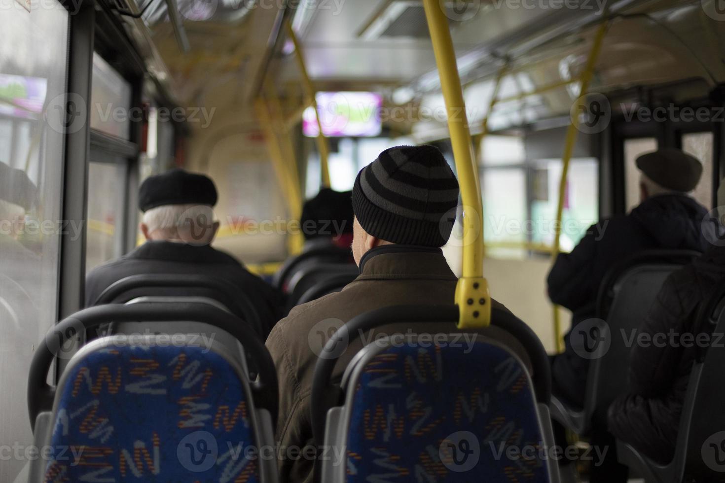 People on bus. Seating on public transport. Seats in interior of bus. Passengers in transport. photo