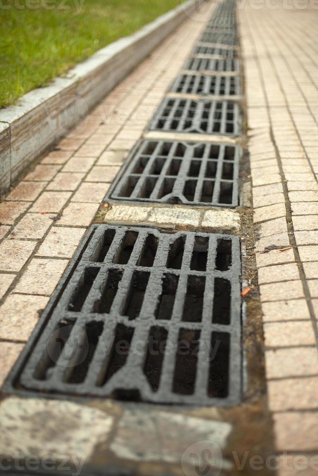 Storm drain for water drainage. Details of urban communications. Canal hatches. Grate on road. photo