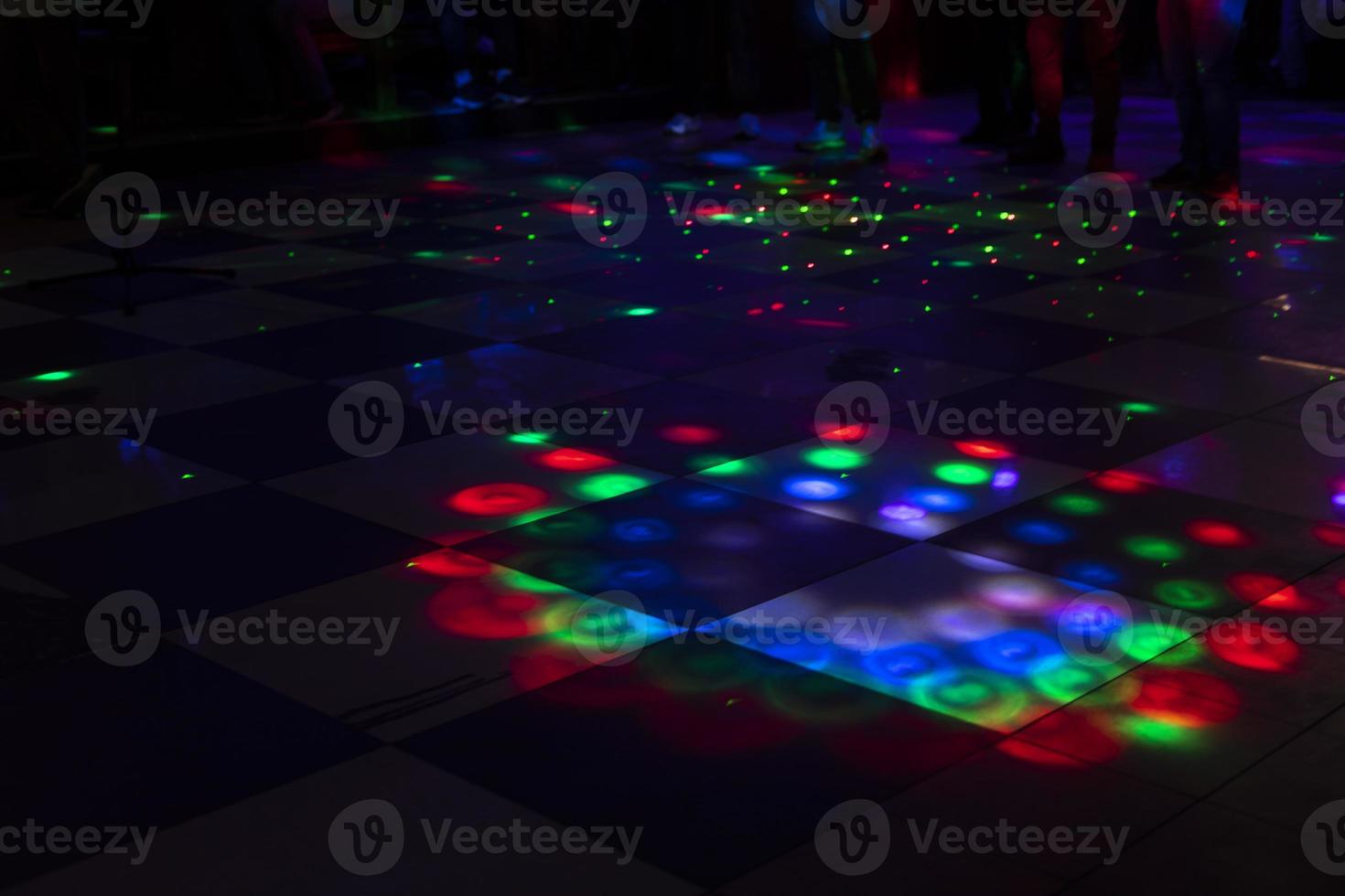 Disco on dance floor. Flower spots on floor. Color music indoors. photo