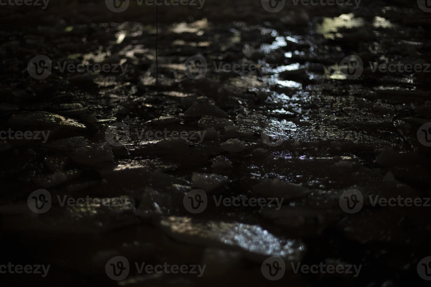 Light on ice in dark. Reflection of artificial light on frozen water. photo