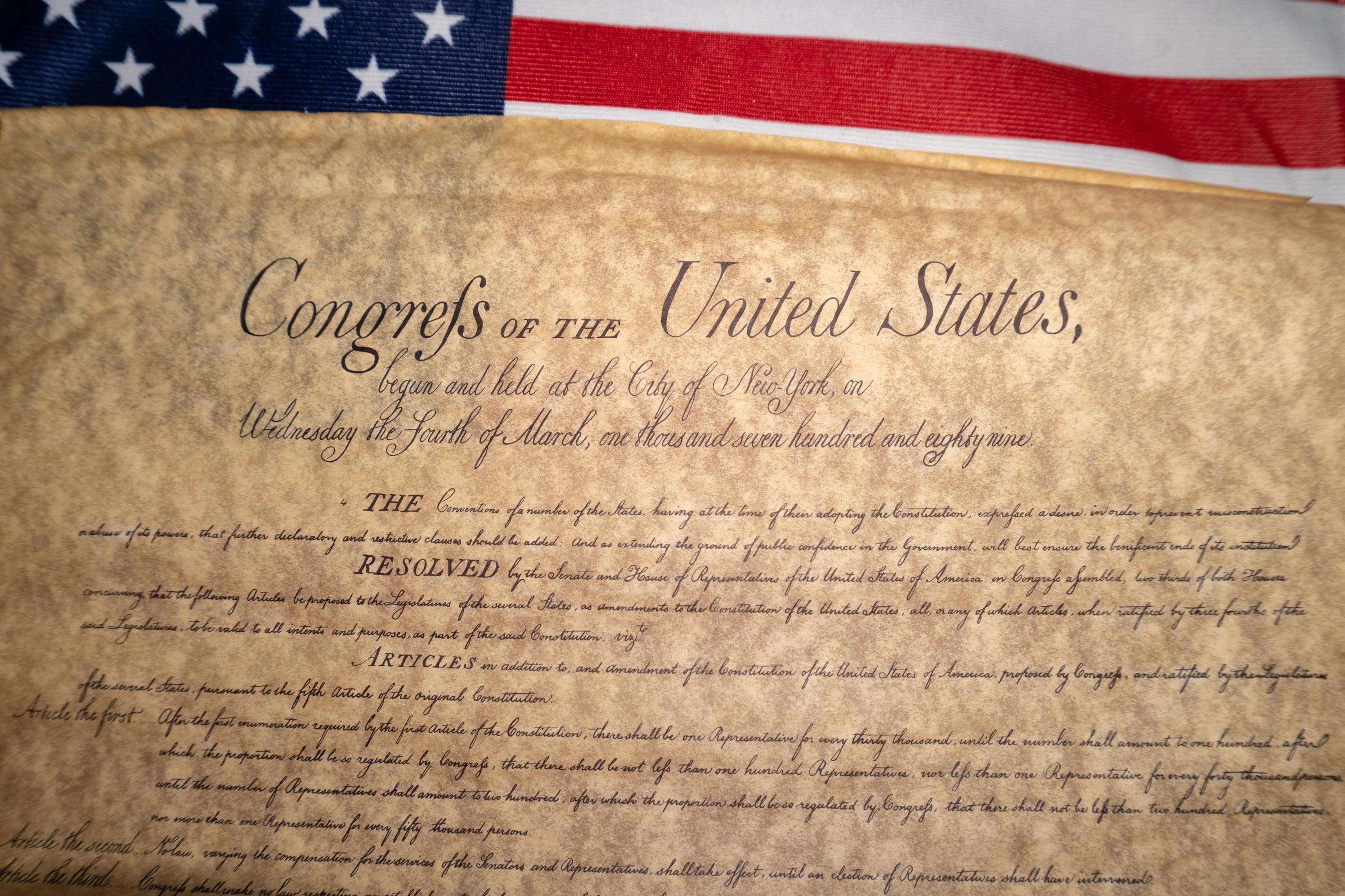 US Constitution document with American flag background