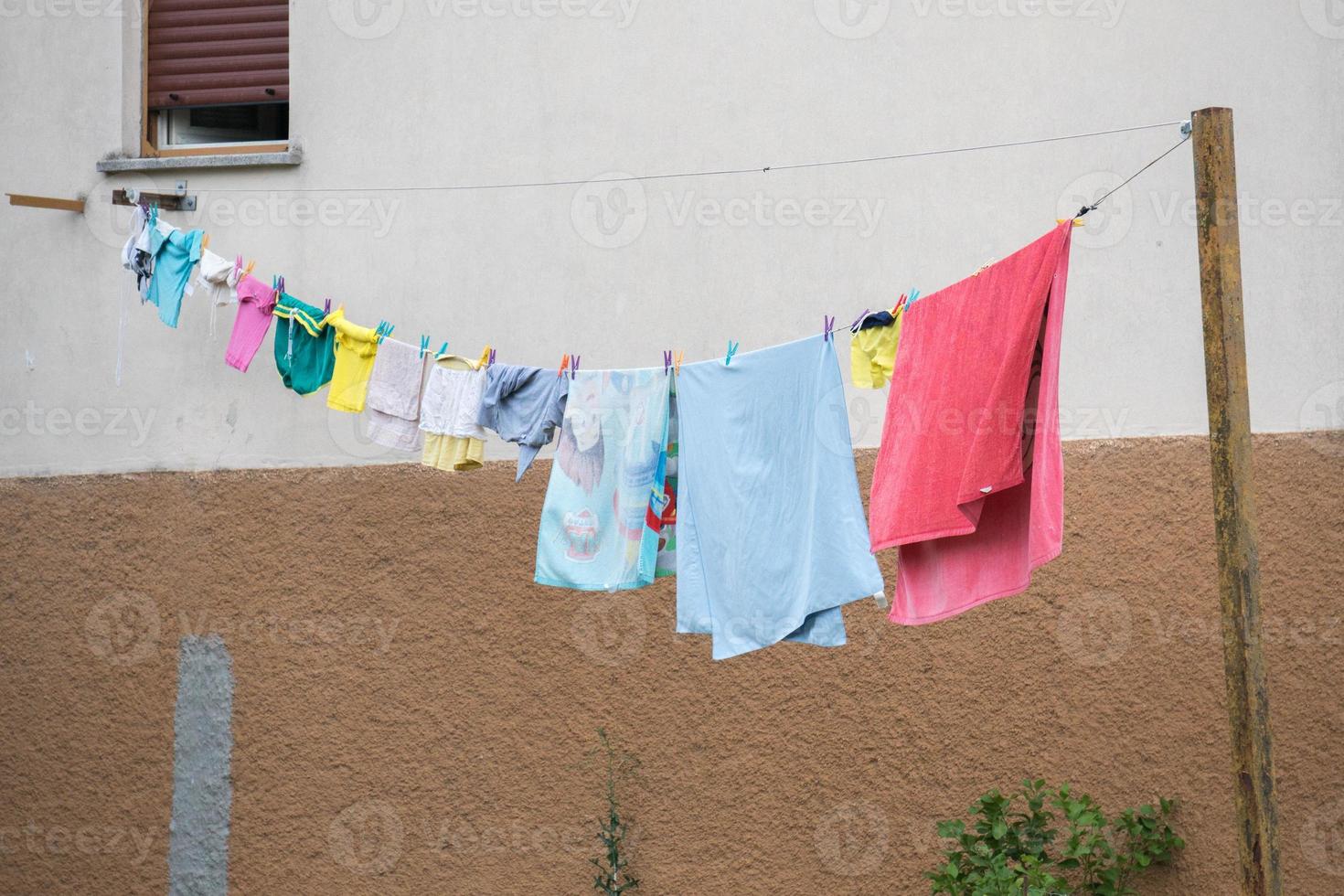 clothes hanging outside house drying to the sun photo