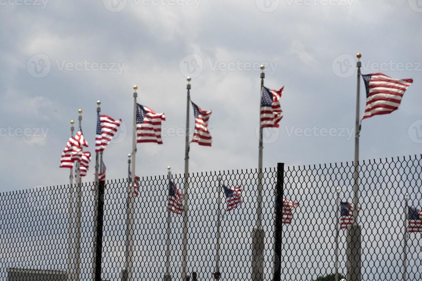 Waving usa flags behind fence grid photo