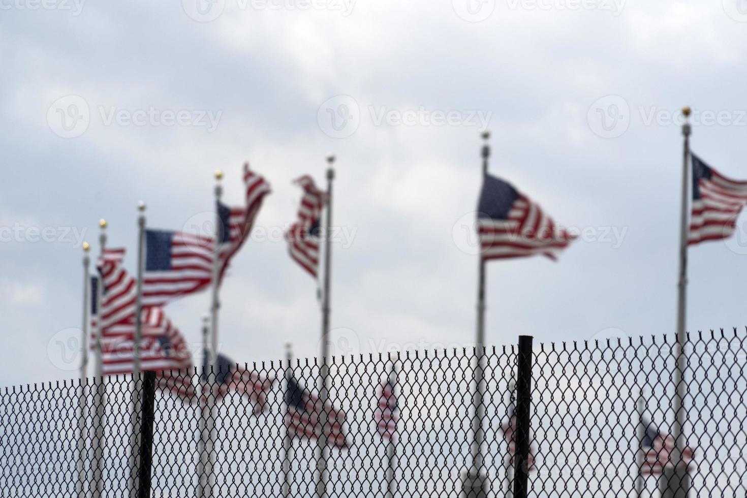 Waving usa flags behind fence grid photo