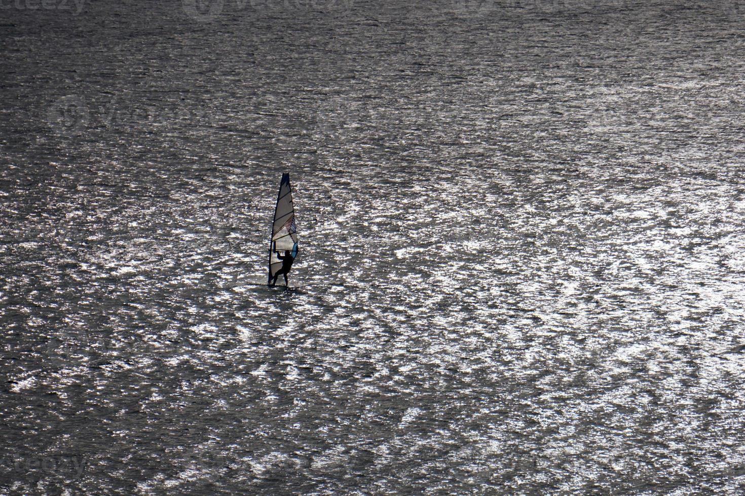 Windsurfer silhouette on the backlight photo