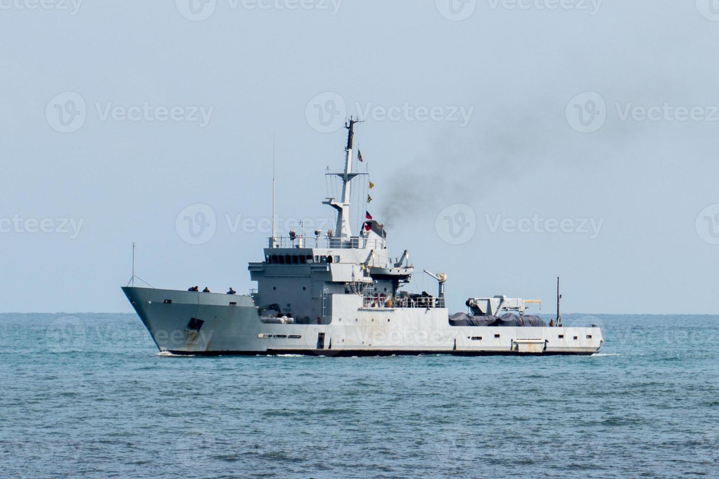 buque de guerra destructor en acción para el barco de migrantes foto