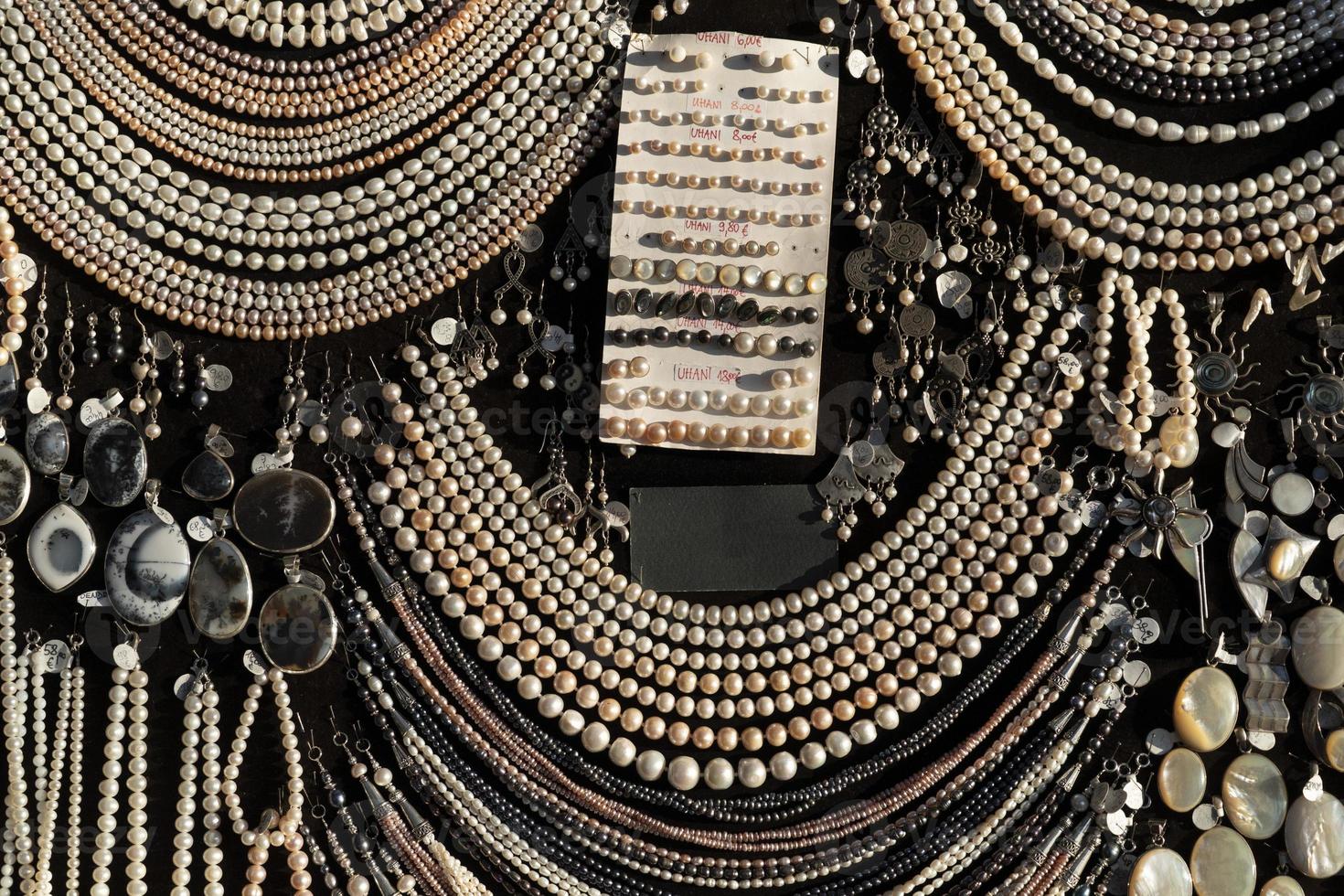 Pearl necklage earrings jewelry on display stand in a shop market photo
