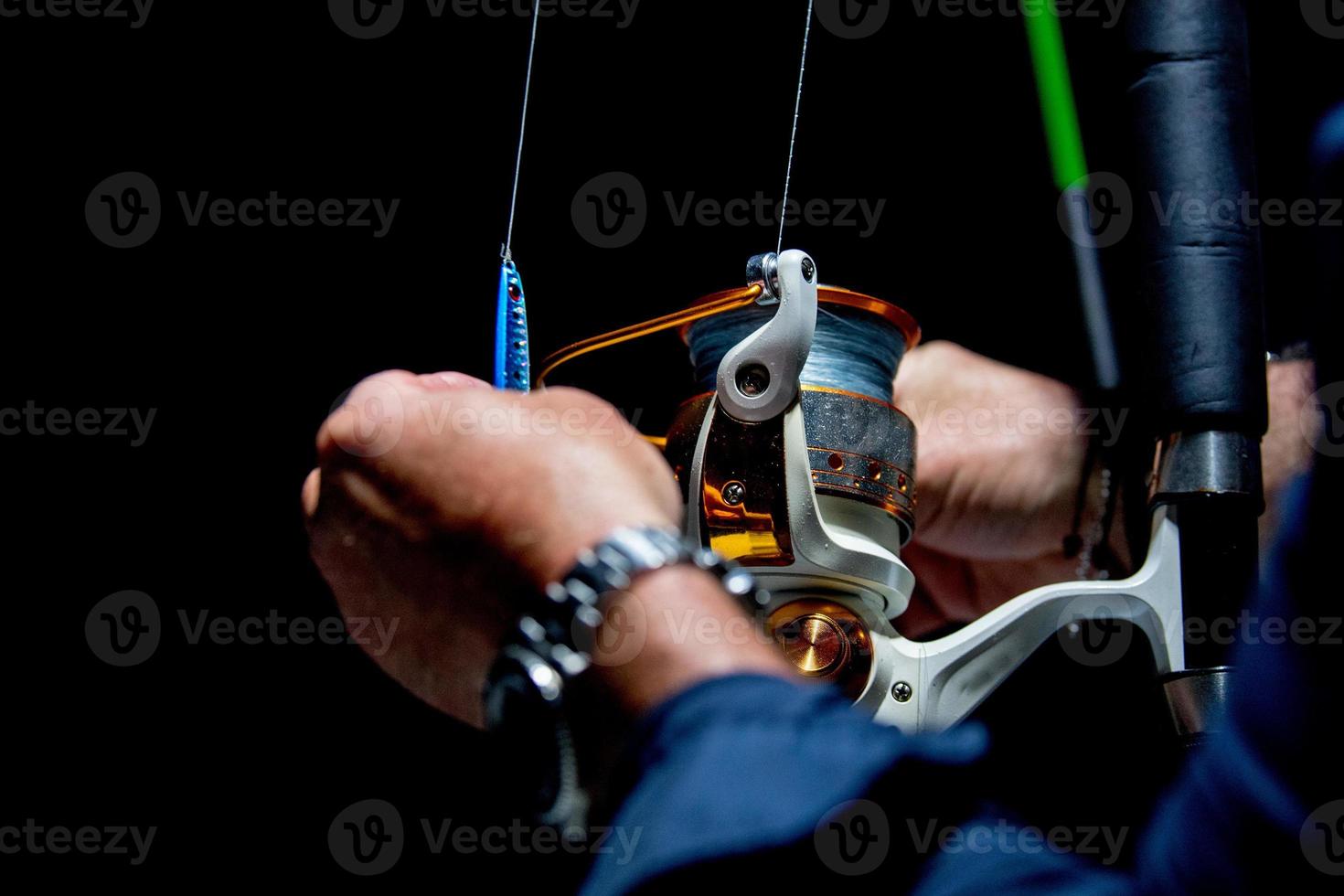 Fishing reel tackle isolated on black photo