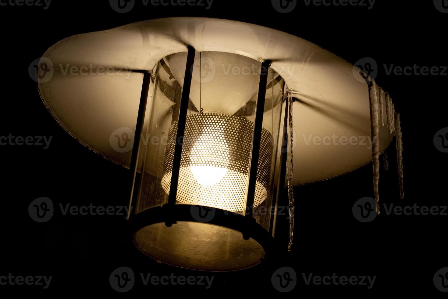 lantern with icicles light in the snow photo