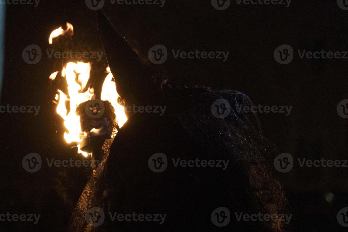 witch in the black holding a torch photo