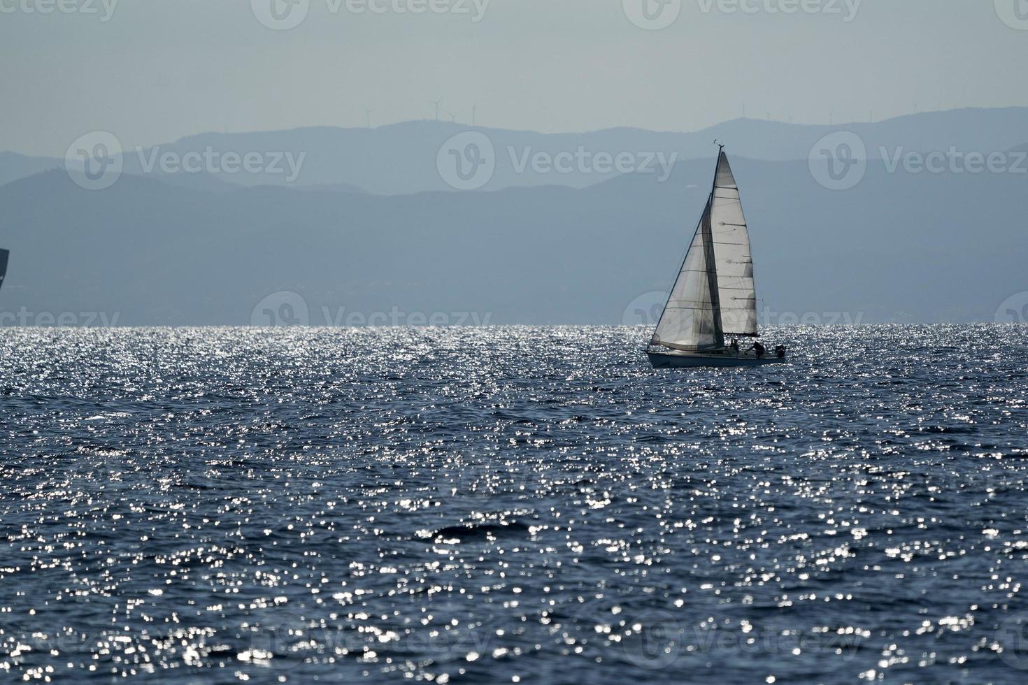 small sailboat on deep blue sea photo