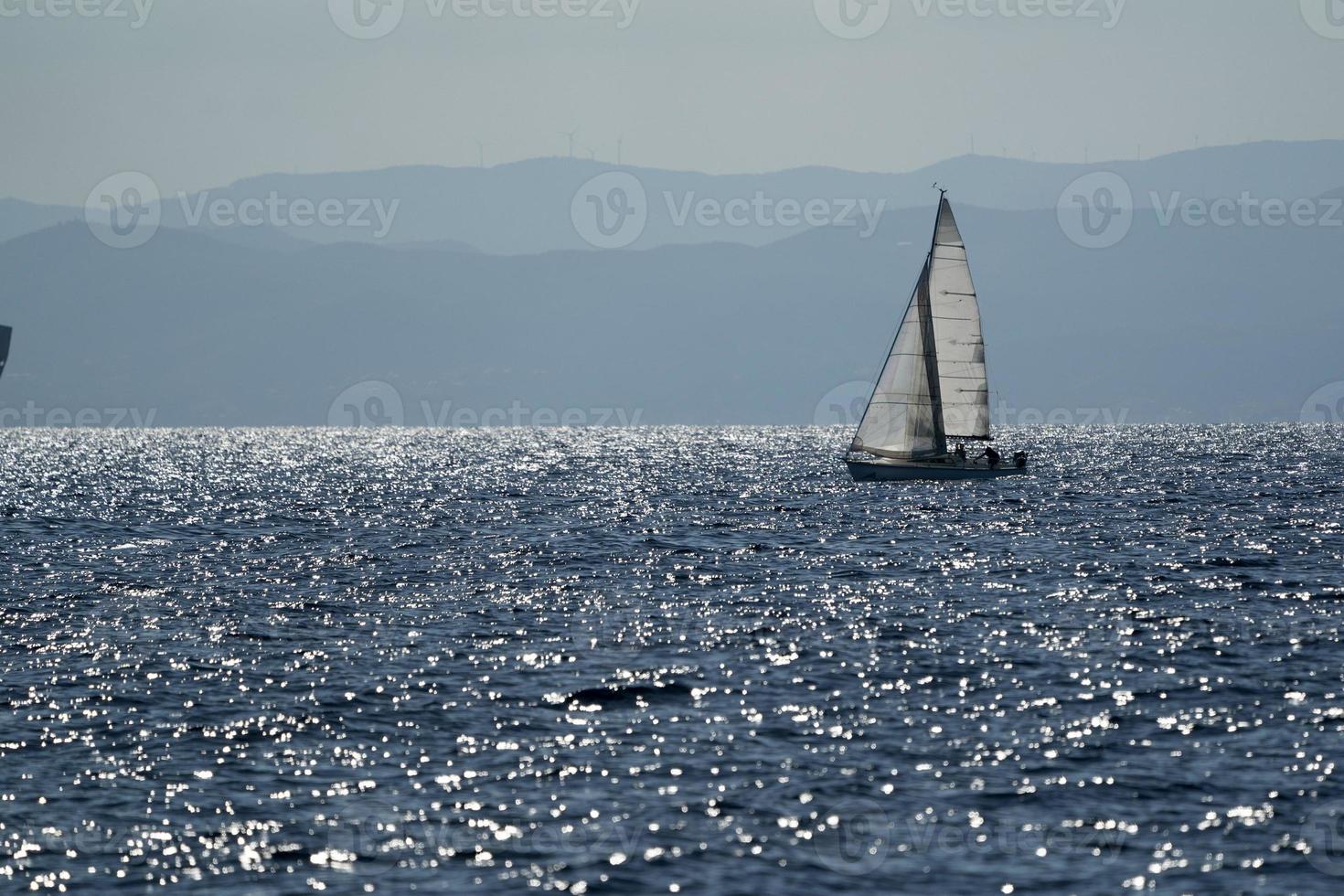 pequeño velero en el mar azul profundo foto