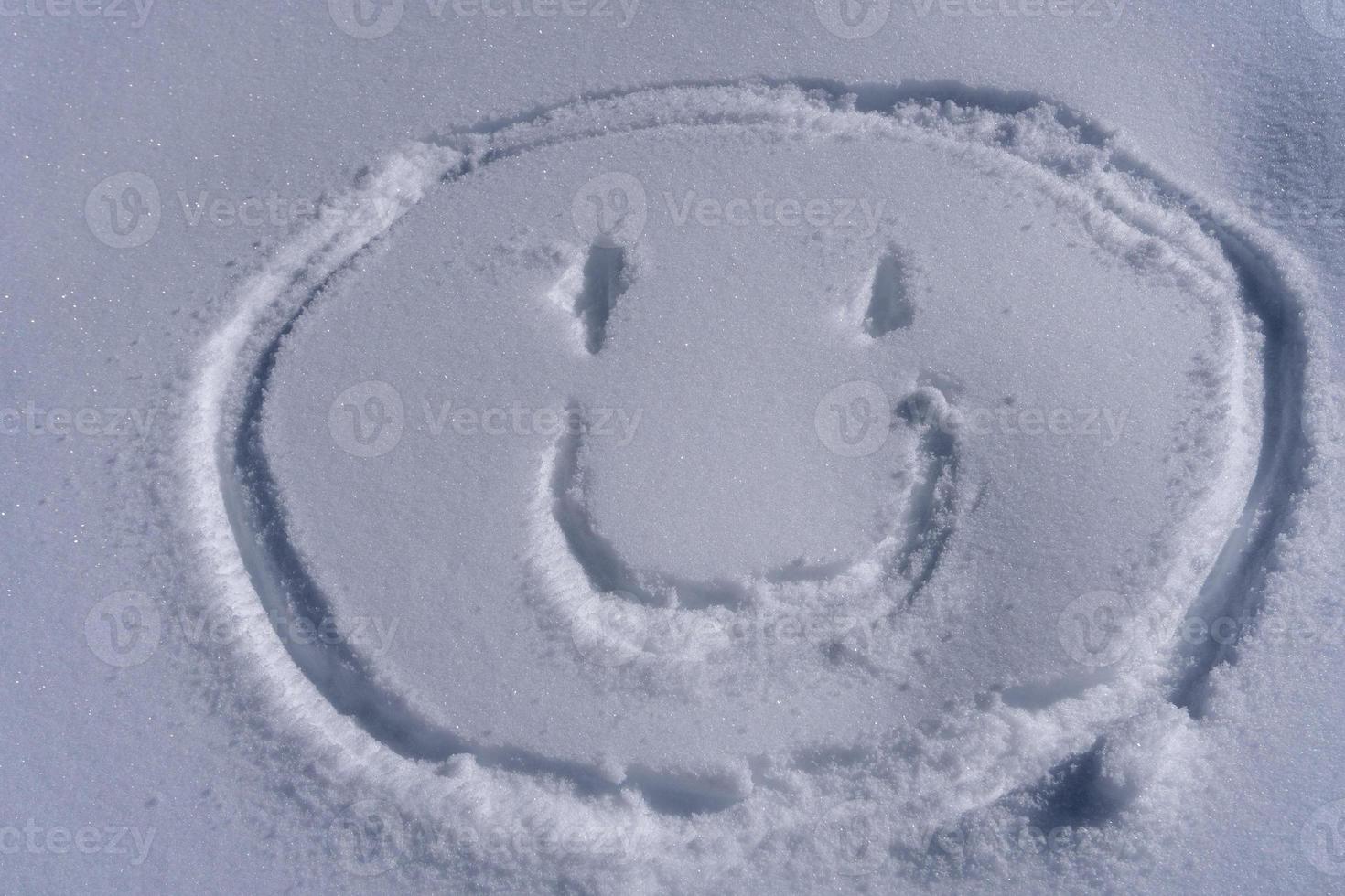 smile face emoticon writing on the snow photo