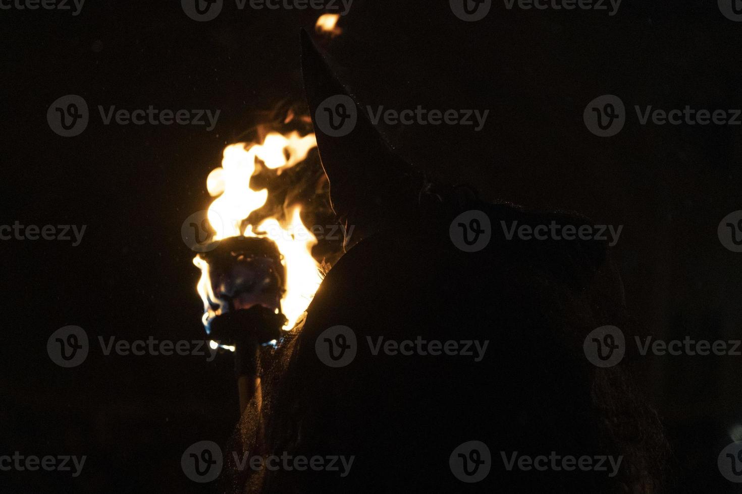 witch in the black holding a torch photo