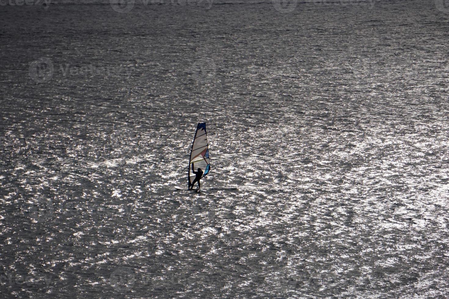 Windsurfer silhouette on the backlight photo