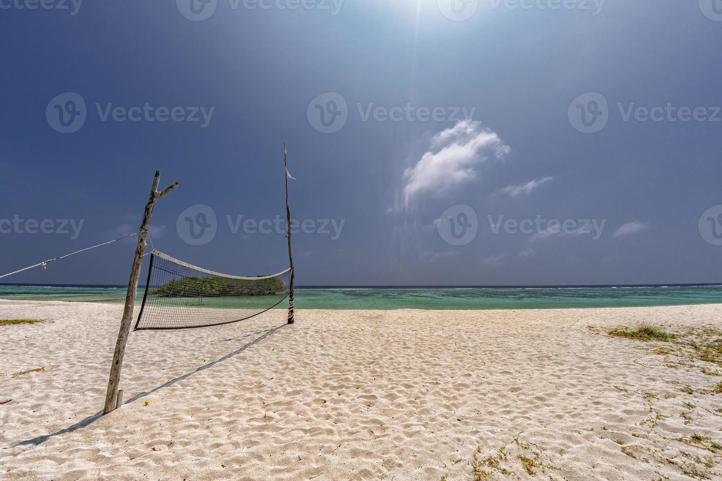 red de voleibol en playa tropical foto