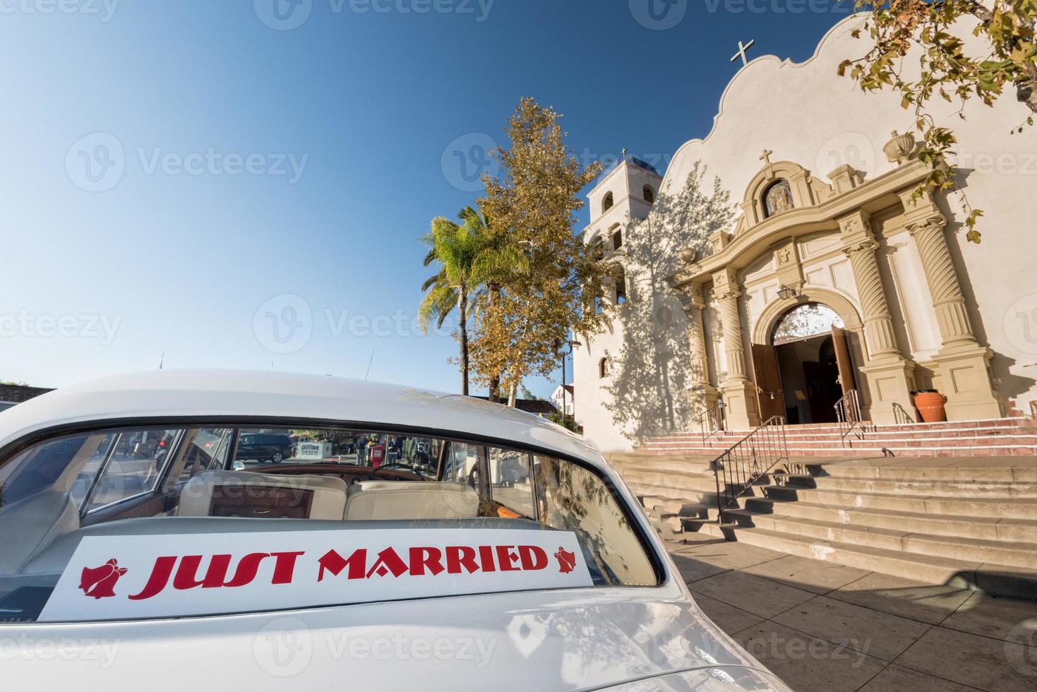 coche blanco recién casado fuera de la iglesia foto