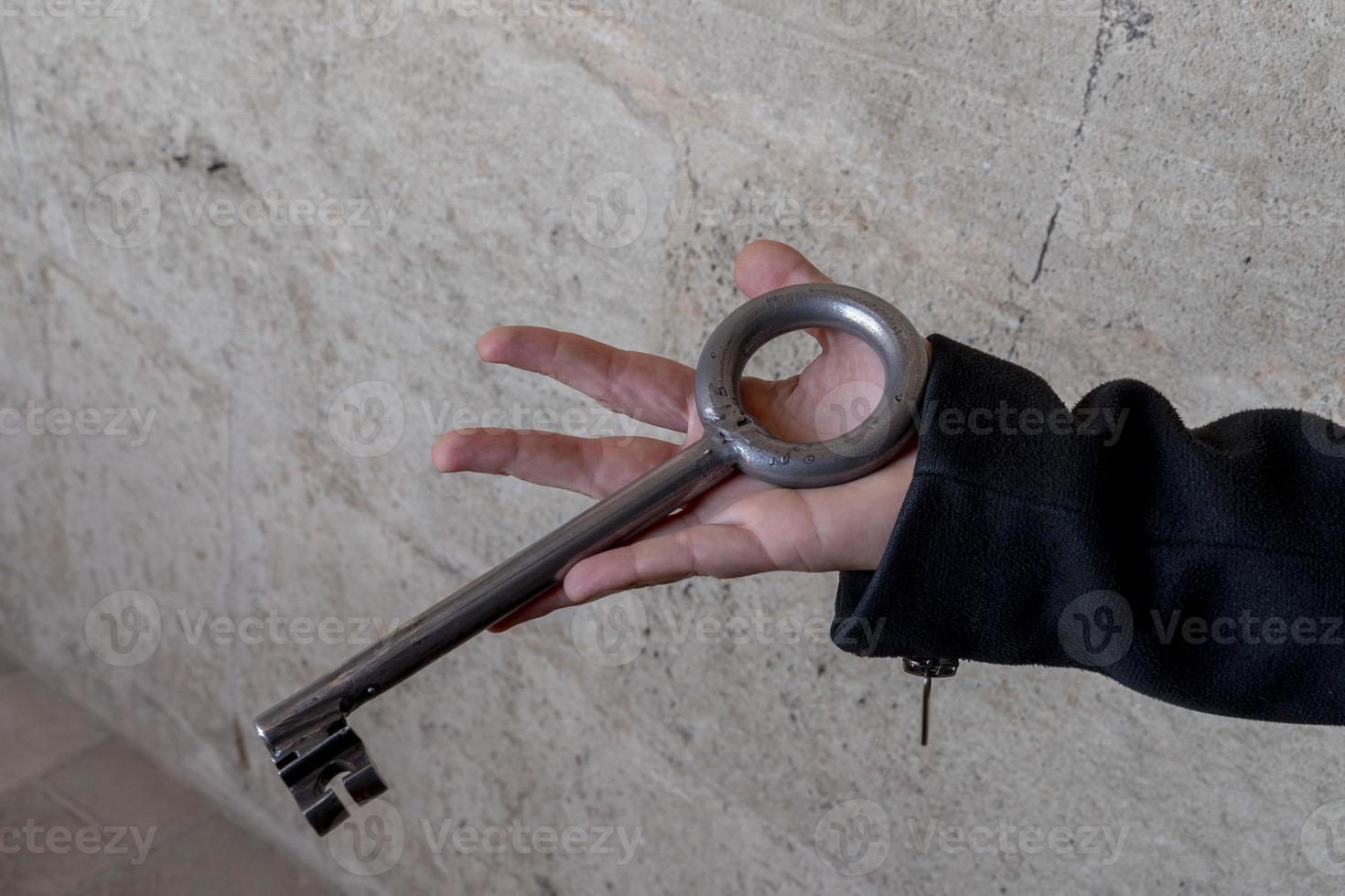 hand holding giant iron medieval key photo