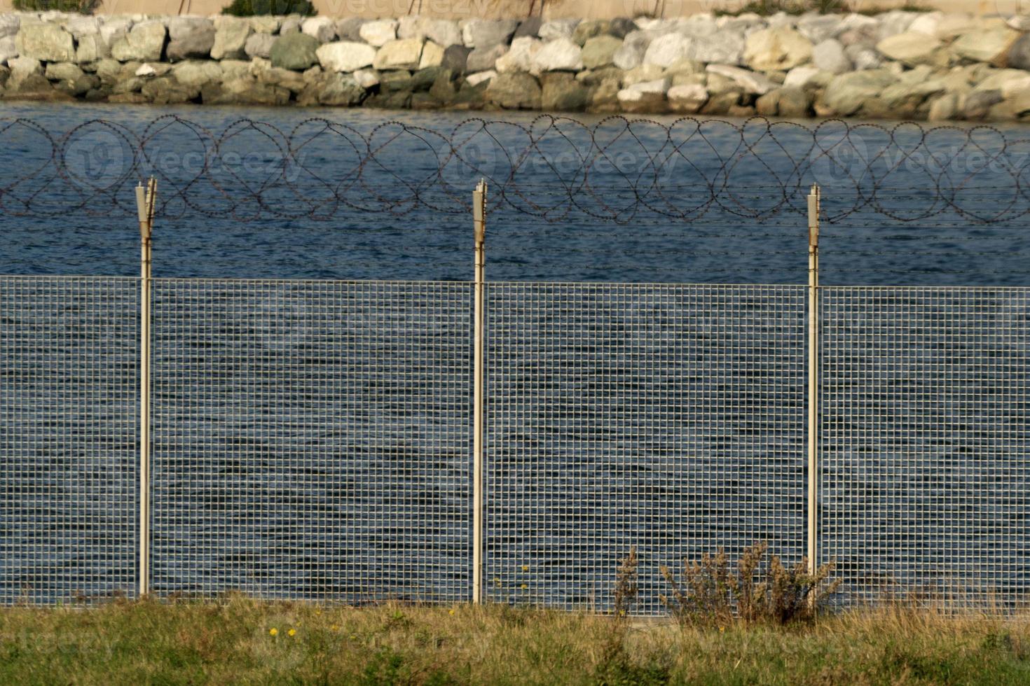barbed wire fence detail near the sea photo