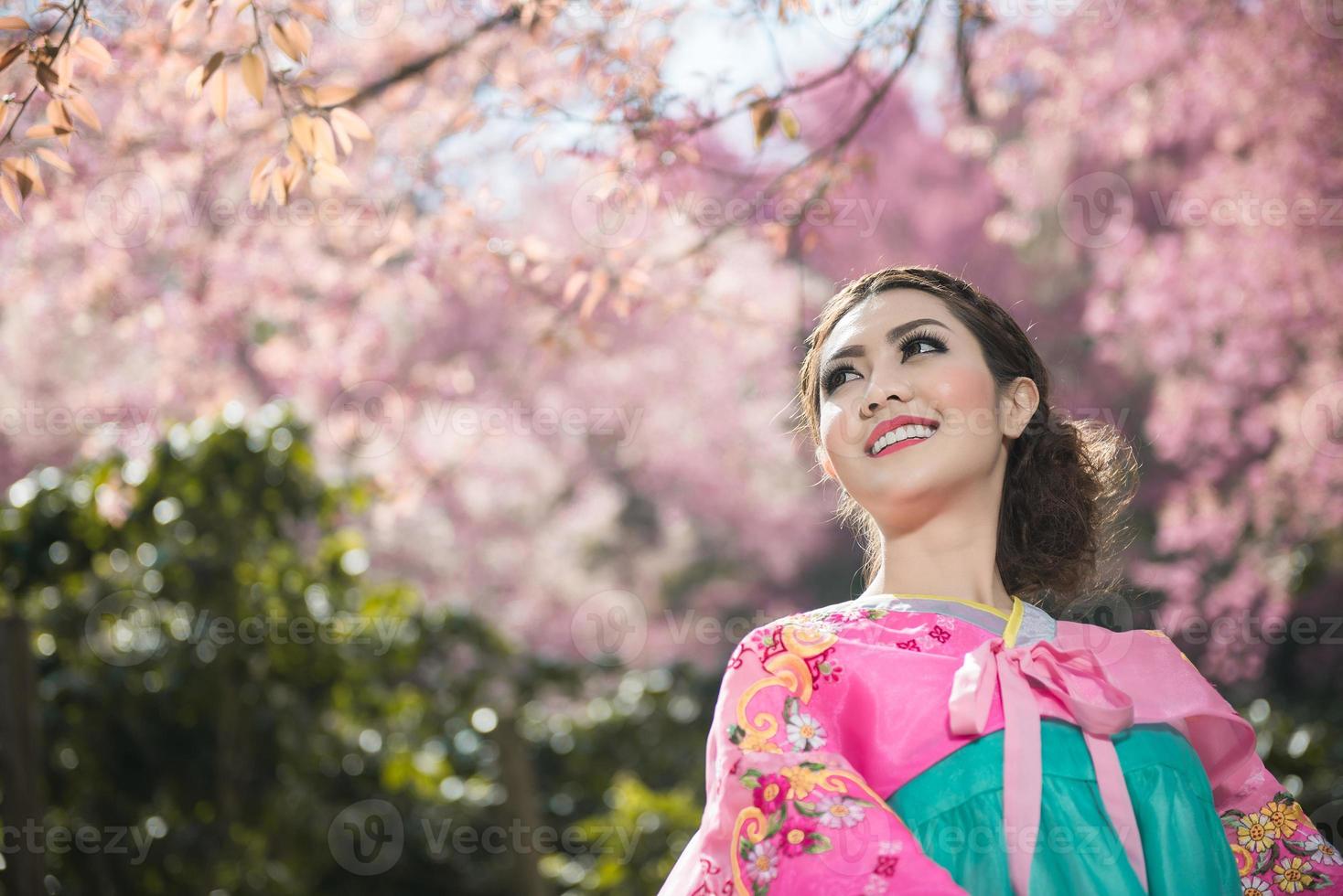 hanbok, el vestido tradicional coreano y hermosa chica asiática con sakura foto