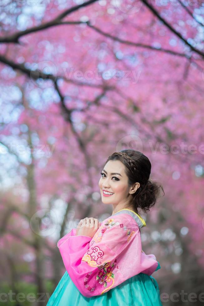 hanbok, el vestido tradicional coreano y hermosa chica asiática con sakura foto