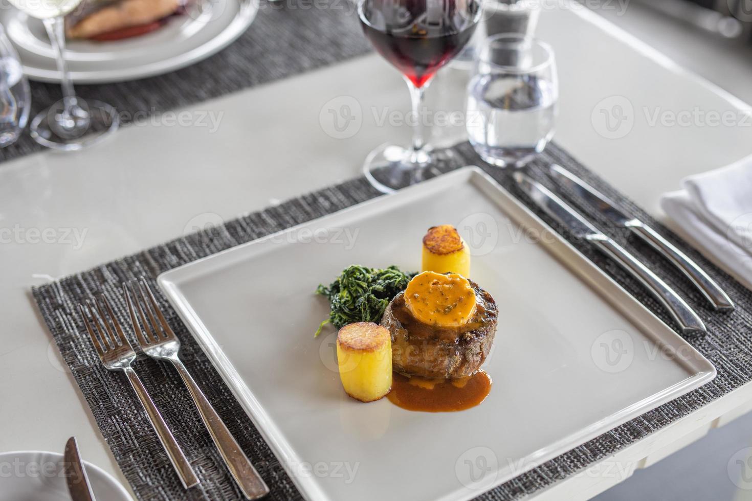 Tenderloin steak wrapped in bacon with demi-glace sauce with smashed potatoes with red wine. Modern restaurant table top view, gourmet food closeup. photo