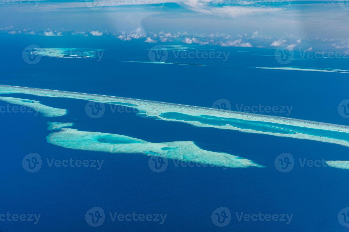 Aerial view of Maldives resort, luxury travel destination. Birds eye view of deep blue sea, coral reed, tropical island. Amazing nature view, drone aerial landscape photo