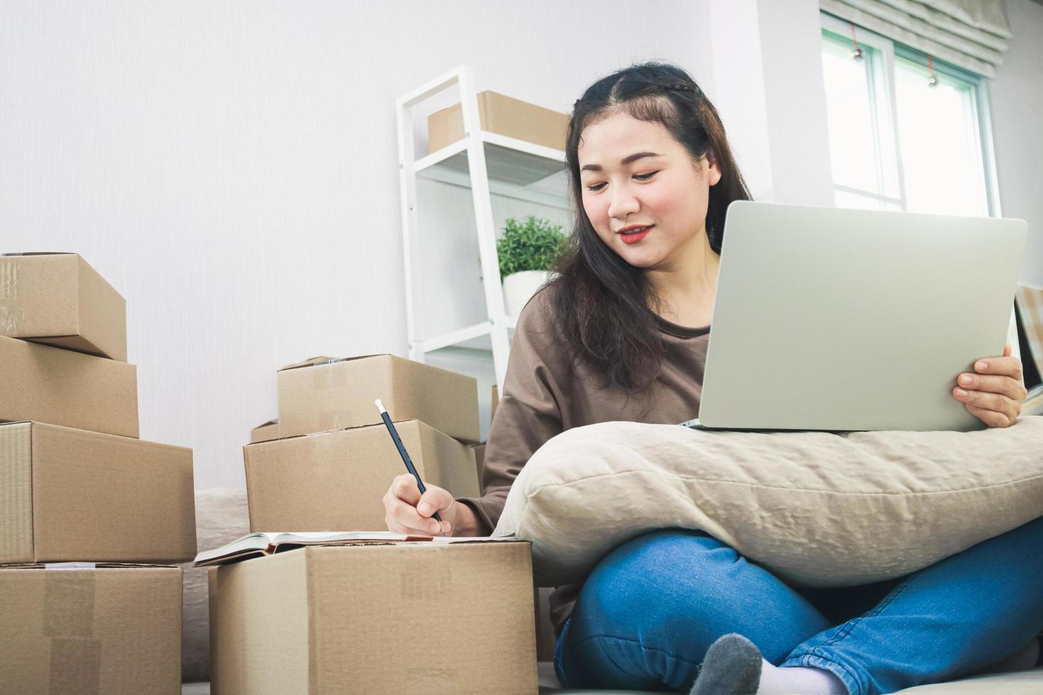 Teenage entrepreneurs Doing business online, delivering products by post, she is writing customer information and preparing packaging. Modern business concepts photo