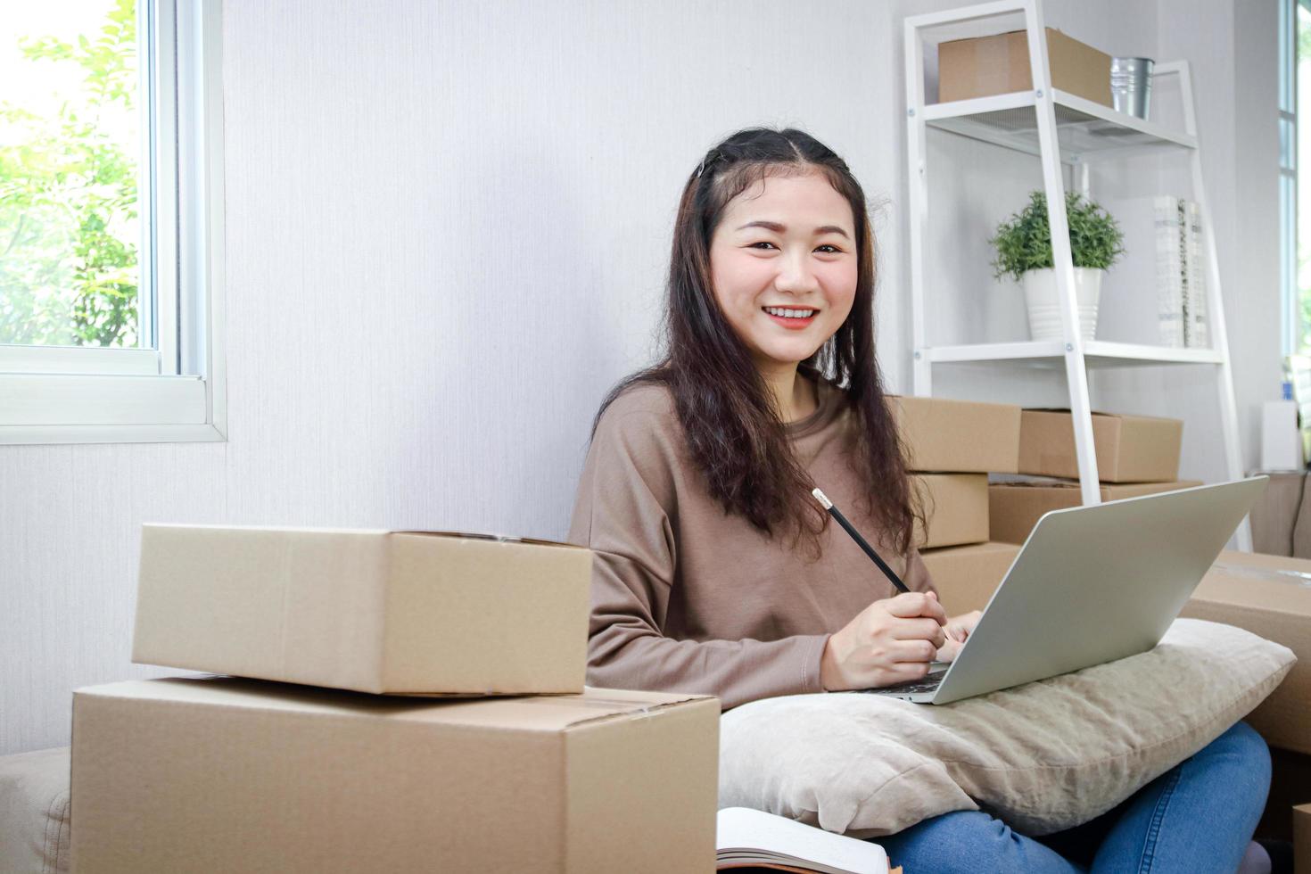 Teenage entrepreneurs Doing business online, delivering products by post, she is writing customer information and preparing packaging. Modern business concepts photo