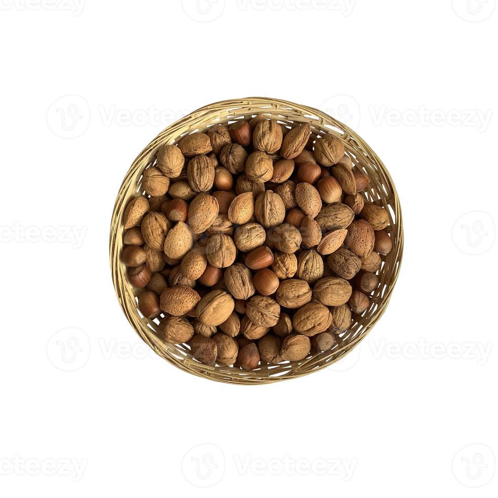 Dried nuts in wicker bowl isolated object top view, soft focus clipping path, pistachio, hazelnuts, walnuts, healthy raw food organic diet concept photo