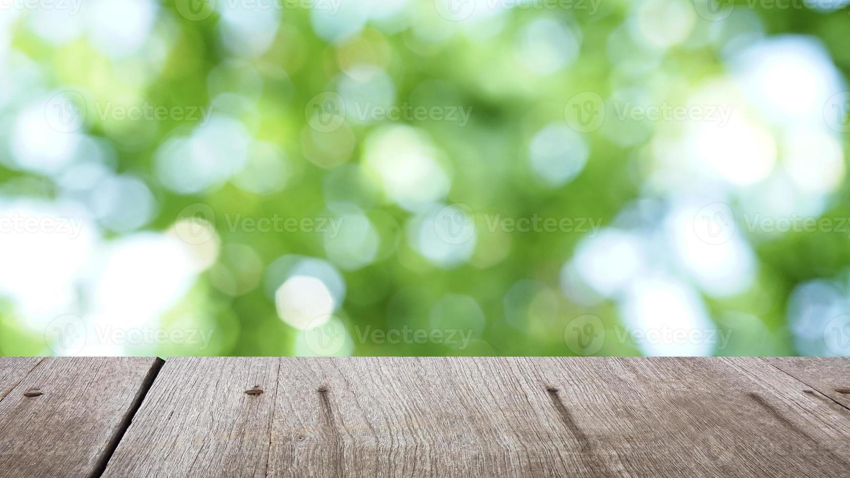 Green bokeh background with brown wood plate . photo