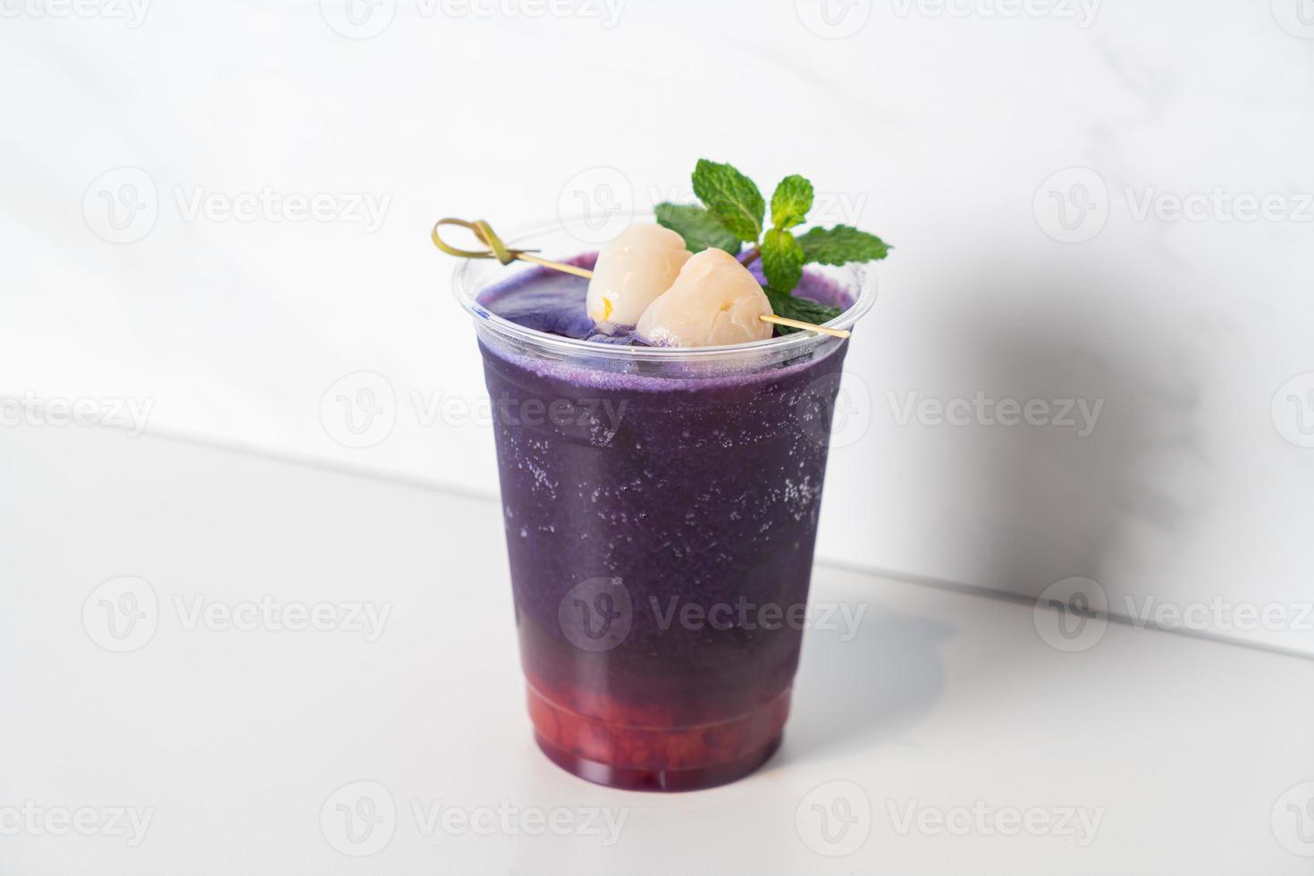 strawberry syrup and butterfly pea juice with fresh lychee on top photo