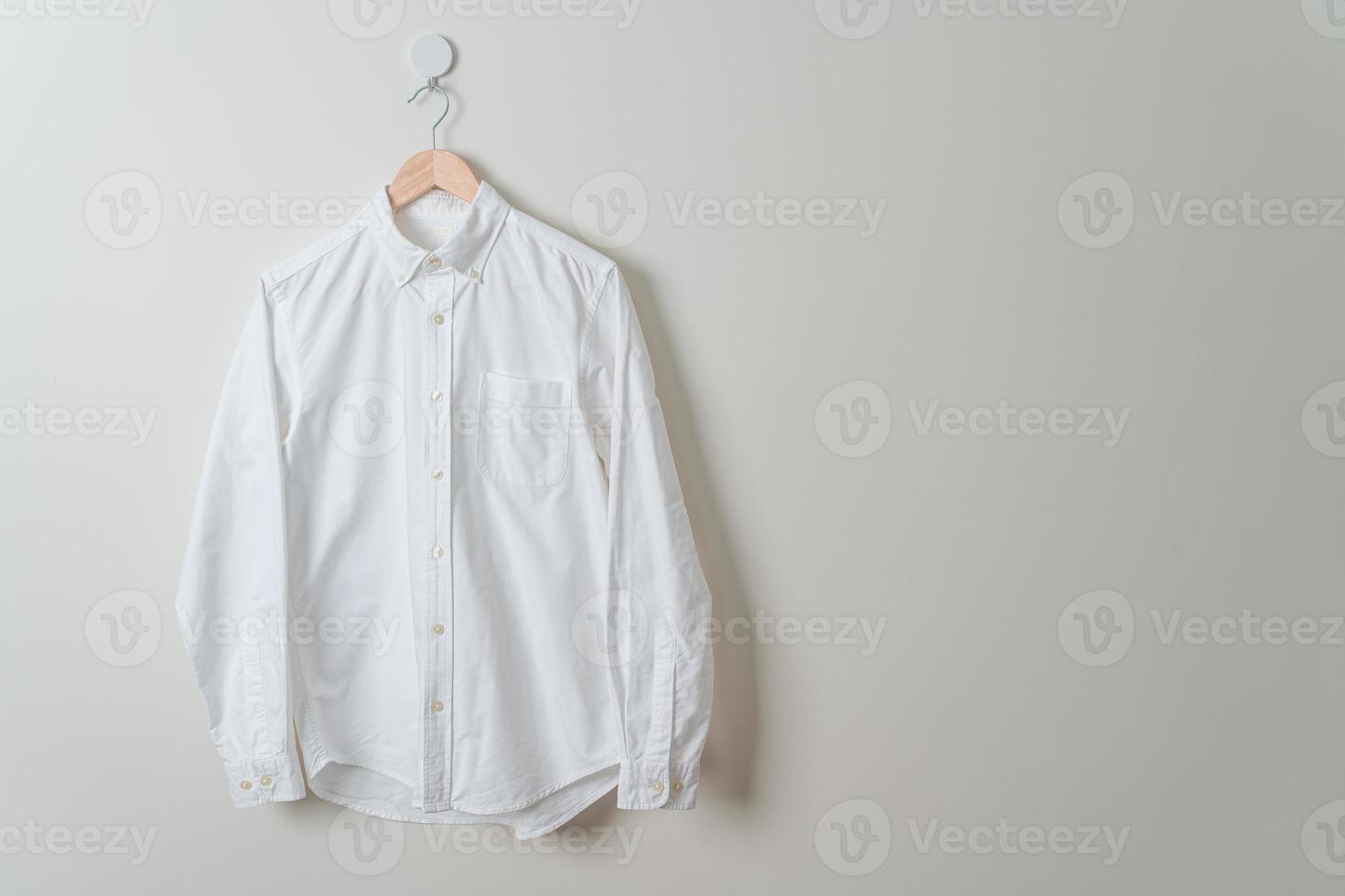 hanging shirt with wood hanger on wall photo