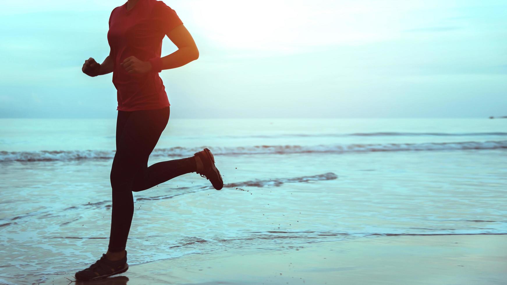 Woman jogging workout on the beach in the morning. Relax with the sea walk. photo