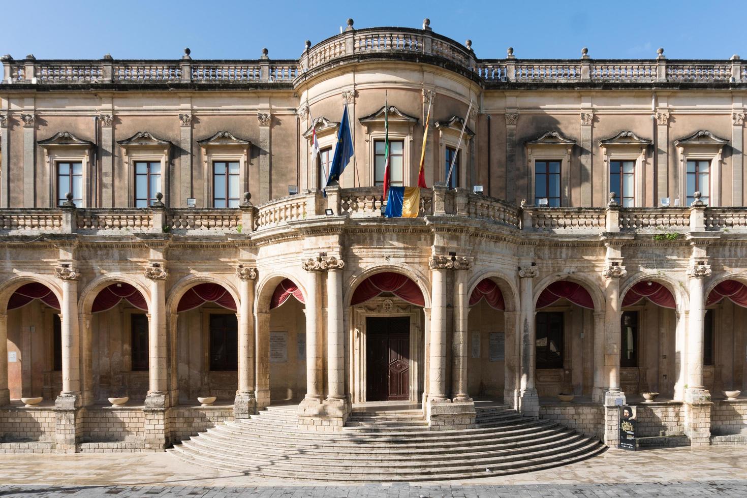 Noto,Italy-May 8, 2022-View of the Ducezio palace from from the top of the stairway of the Cathedral during a sunny day photo
