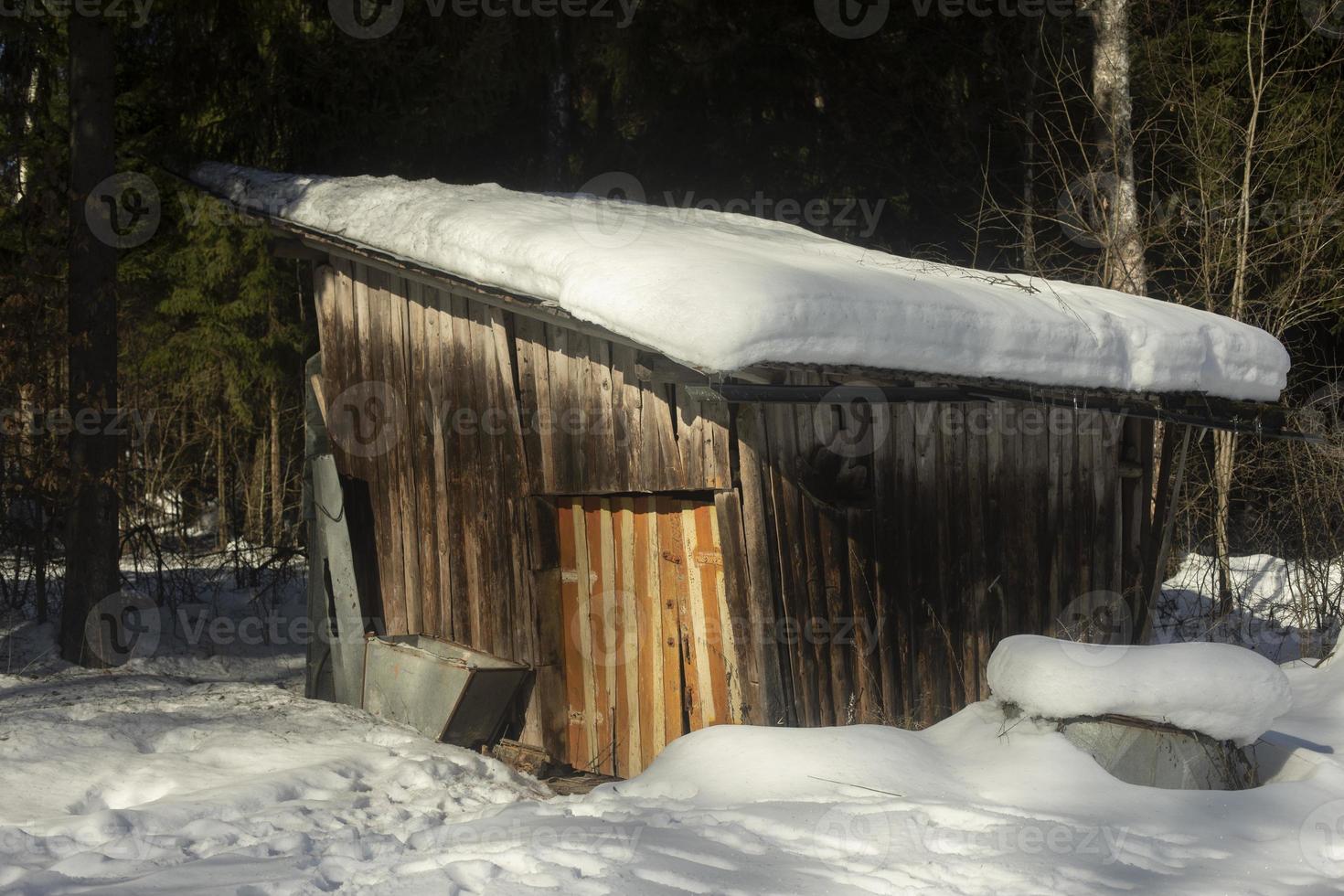 nieve en el techo del granero de madera. casa de Campo. invierno en el pueblo. foto