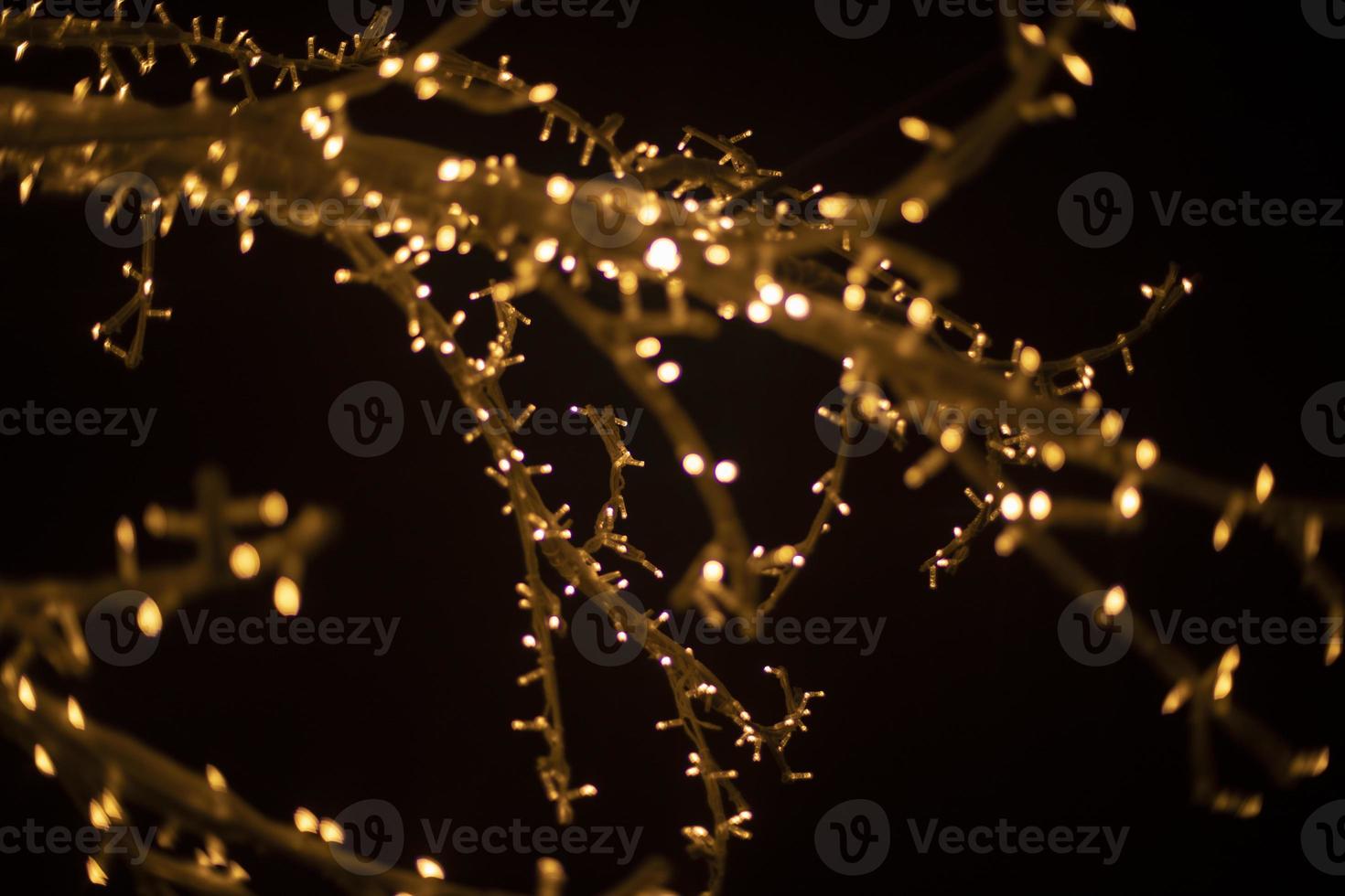 Yellow lights in dark. New Year's texture. Wood made of garlands. Lots of lights. photo